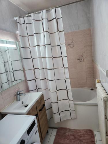 a bathroom with a tub and a sink and a toilet at Champions Deluxe in Sarcelles