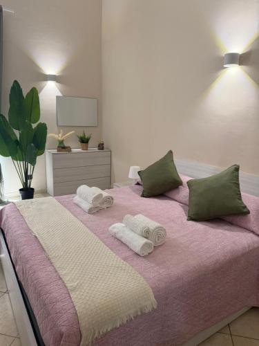 a bedroom with a pink bed with towels on it at Guest House Via Poerio in Catanzaro