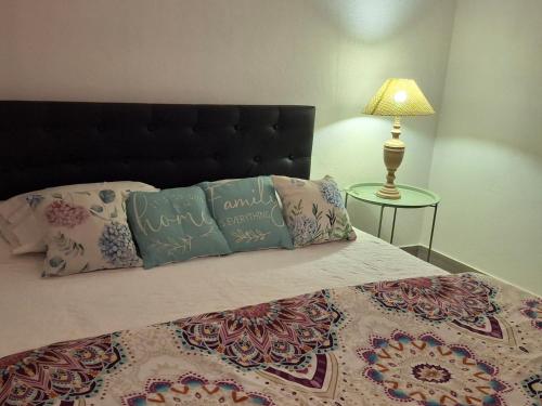 a bedroom with a bed with pillows and a lamp at Casa da Avenida in Mértola