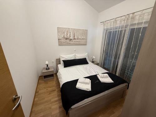a bedroom with a bed with two towels on it at Apartments Eva in Malinska