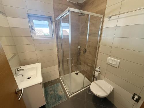 a bathroom with a shower and a toilet and a sink at Apartments Eva in Malinska