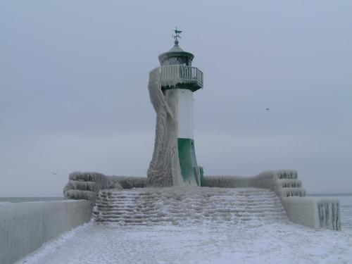 a lighthouse on the beach with snow on the stairs at Fischerhaus König in Alt Sassnitz in Sassnitz