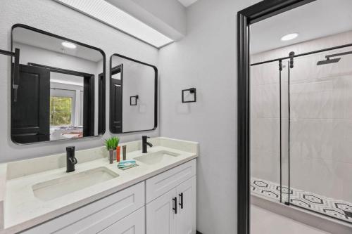 a bathroom with two sinks and a glass shower at Hawthorn Suites Suite Near Universal & I-Drive in Orlando