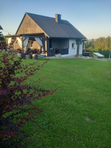 a barn with a grass field in front of it at Domek Pod Prehybą -Agroturystyka in Gaboń