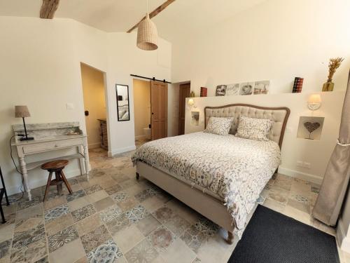a bedroom with a bed and a desk in it at Gîtes climatisés classés 4 étoiles Au Petit Bonheur de Lorigné in Lorigné