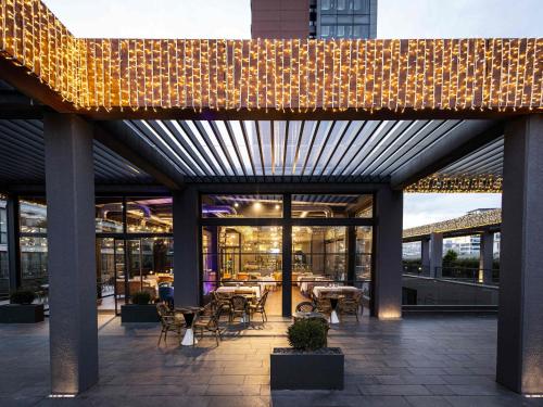 a patio with tables and chairs in a building at Movenpick Living Istanbul West in Istanbul