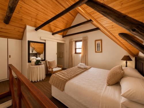 a bedroom with a large bed and a wooden ceiling at Baviana Beach Lodge - Jacobsbaai - Jacobs Bay in Jacobs Bay