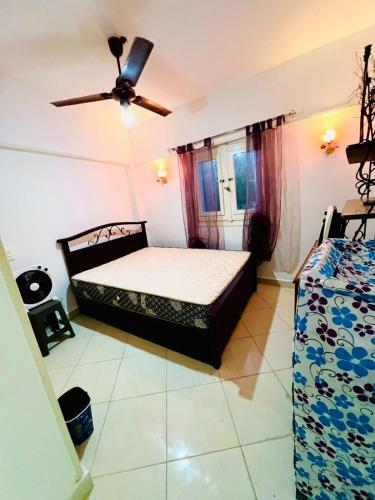 a bedroom with a bed and a ceiling fan at شاليه in Dawwār Abū Maḩrūs