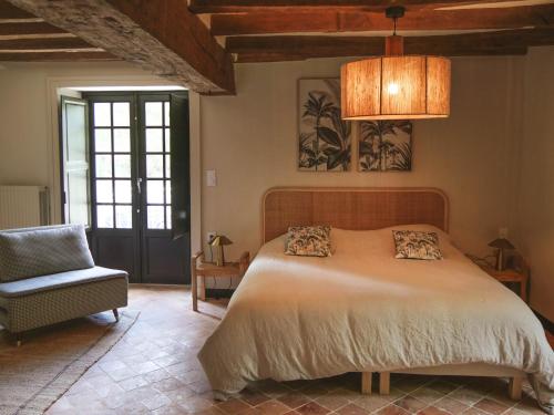 a bedroom with a large bed and a chair at Manoir Du Moulinet in Château-Gontier