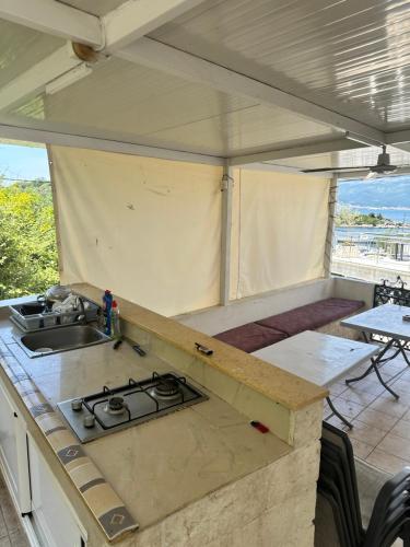a kitchen with a stove and a sink in a tent at Apartmani Bjelila in Tivat