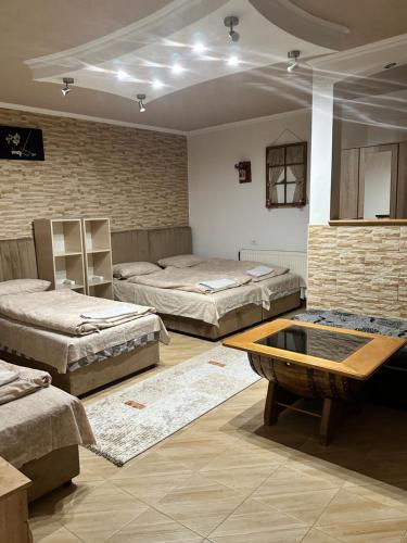 a room with three beds and a table in it at Apartmani Bjelila in Tivat