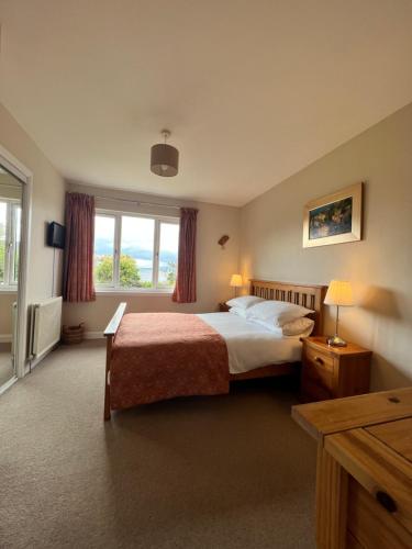 a hotel room with a bed and a window at The Rowans B&B in Connel