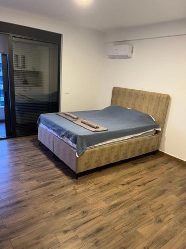 a large bed in a room with a wooden floor at Alex apartment Bar in Bar