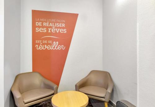 two chairs and a table in a room at B&B HOTEL Dunkerque Centre Gare in Dunkerque