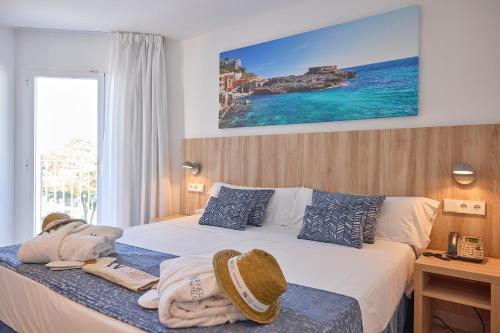a hotel room with a bed with towels on it at INNER Hotel Rupit "Adults Only" in Cala d´Or