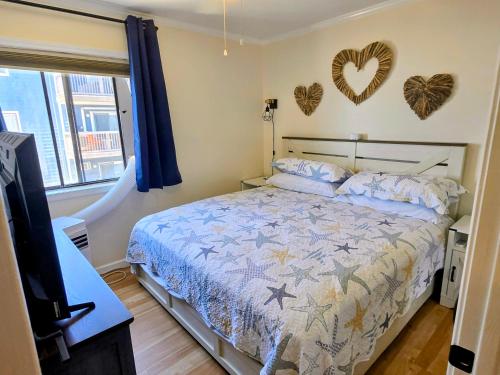 a bedroom with a bed and hearts on the wall at Steps to the Ocean! 219 in North Topsail Beach