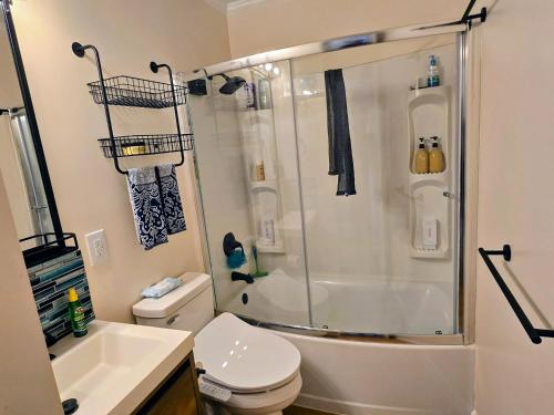 a bathroom with a shower and a toilet and a sink at Steps to the Ocean! 219 in North Topsail Beach