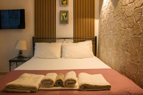 a bedroom with a bed with towels on it at Zoli house in Pefkochori