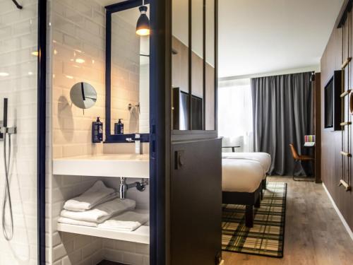 a bathroom with a sink and a bed in a room at ibis Styles Castelnaudary in Castelnaudary