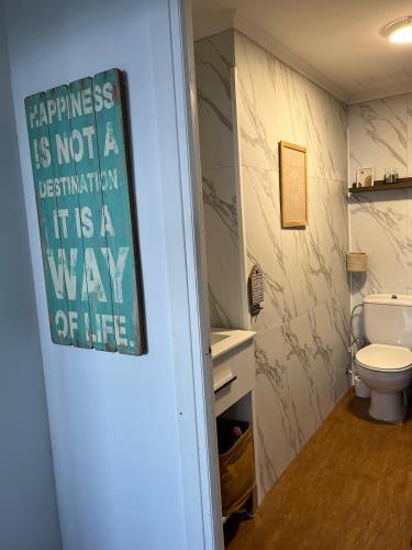 a bathroom with a toilet and a sign on the door at Ibinaga Seaview - Auto checking property in Ibarrangelu