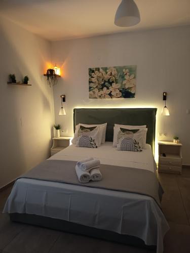 a bedroom with a large bed with two towels on it at Iason studio 4 in Patitiri