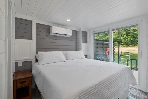 a bedroom with a white bed and a window at Miss Madison - Pet Friendly Floating House in Russell Springs