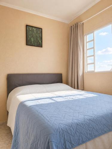 a bedroom with a large bed with a window at Ampla, com 5 vagas de carro e bem próxima das empresas da região in São José dos Pinhais