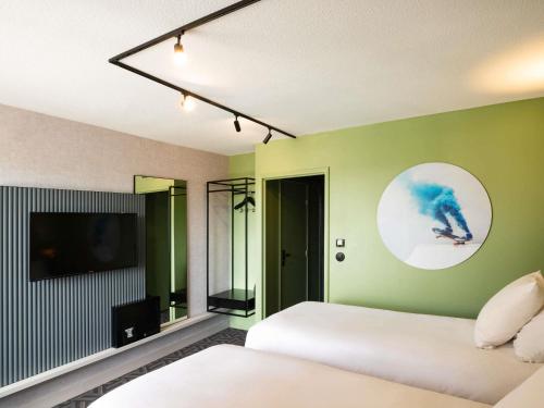 a bedroom with a white bed and a tv at Tribe Carcassonne in Carcassonne