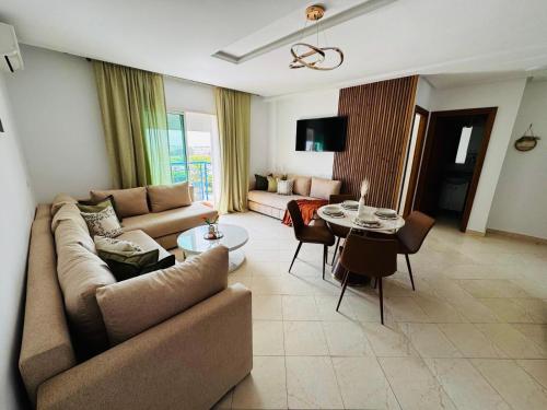 a living room with a couch and a table at CaboNegro Appart Resort, Piscine, Plage, Détente in Cabo Negro