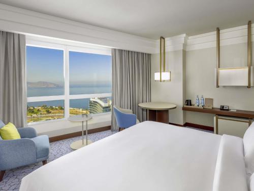 a hotel room with a large bed and a large window at Hotel Oran Bay Managed By Accor in Oran
