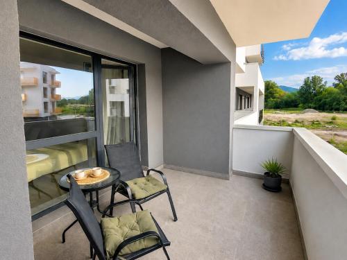 a balcony with a table and chairs and a window at LUMO Terrace Studio with Private Parking near Coresi in Braşov