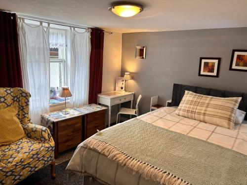a bedroom with a bed and a chair and a window at Beulah Serviced bedrooms in Aberdeen