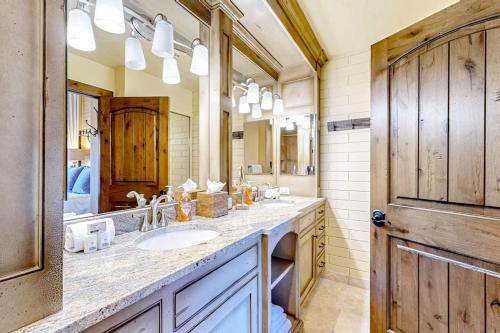 a bathroom with two sinks and a large mirror at The Silver Saddle in Ketchum