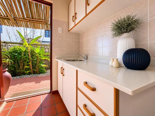 a kitchen with a sink and a vase on a counter at Baviana Beach Lodge - Jacobsbaai - Jacobs Bay in Jacobs Bay