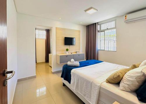 a bedroom with a large bed and a television at Hospede-se com conforto em Capim Macio in Natal