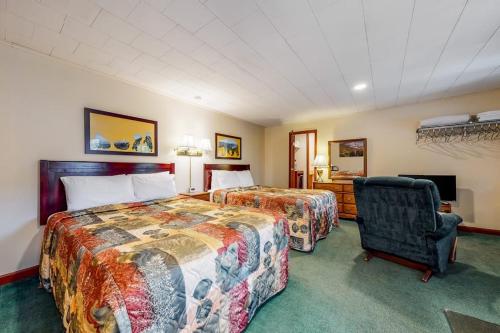 a hotel room with two beds and a chair at Riverbank Connecting Rooms 3 & 5 in Lincoln