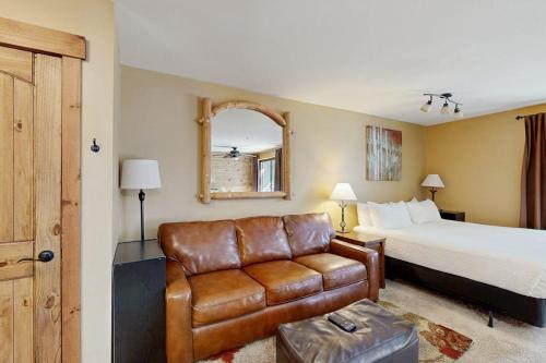 a hotel room with a bed and a leather couch at River Mountain Lodge #W101 in Breckenridge