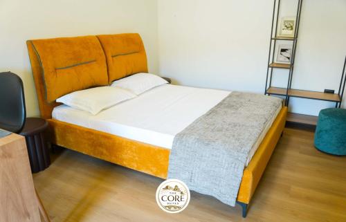 a bedroom with a large bed with a wooden headboard at The Core Lezhe in Lezhë