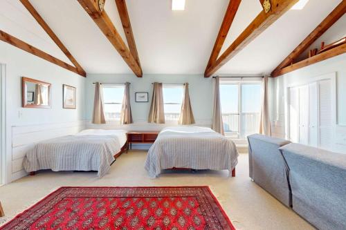 two beds in a room with a couch and windows at Fisherman in Newburyport