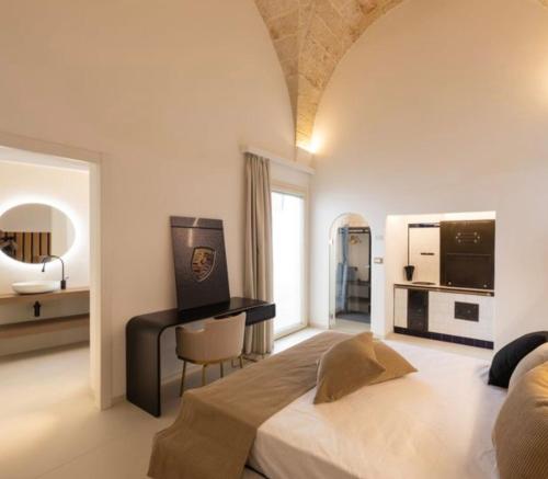 a bedroom with a large bed and a desk at Casa Novecentoundici in Castrignano deʼ Greci
