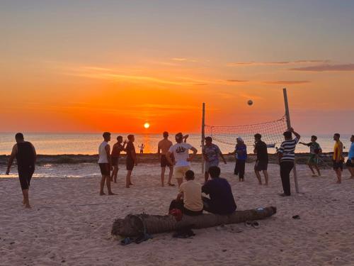 a group of people playing volleyball on the beach at sunset at Wostel Djerba Downtown in Houmt Souk