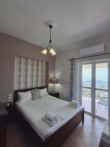 a bedroom with a large bed and a balcony at Elena Rista Studios in Parga
