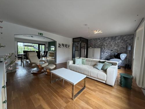 a living room with a white couch and a table at Niederrhein Suite Kerken in Kerken
