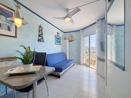 a living room with a blue couch and a table at Apartment Club Nautic-17 by Interhome in Empuriabrava