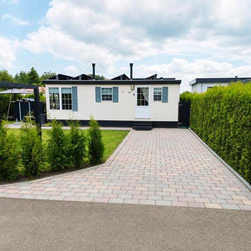 a white house with a brick driveway at Vienna in Dronrijp
