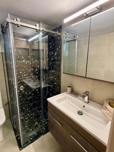 a bathroom with a glass shower and a sink at Mosaic House in Sami