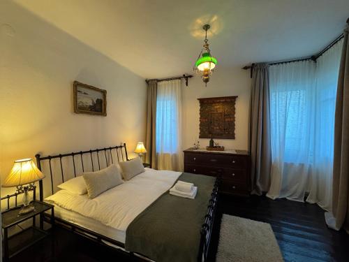 a bedroom with a bed and a chandelier at Casa Alexandra Slătineanu in Bran