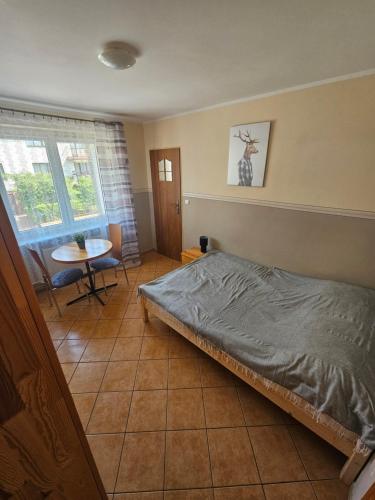 a bedroom with a bed and a table in it at Margaretka in Łeba