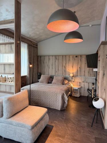 a bedroom with two beds and a chair and a couch at Desimo Home in Piła