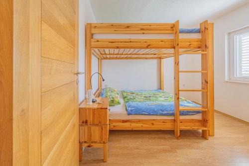 a bedroom with a bunk bed with a ladder at Apartments at Frapa in Rogoznica